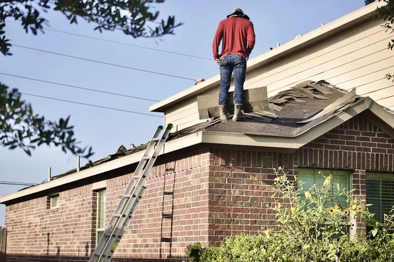 Professional roofer working on a residential roof in Brinley